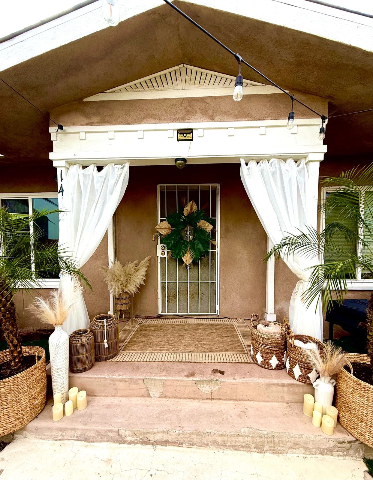 Boho entry with sheer curtains, pampas, baskets and candles